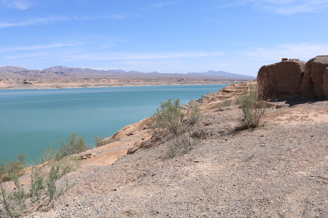 a large body of water sitting next to a rocky cliff
